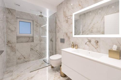 een badkamer met een toilet, een wastafel en een douche bij Stunning Athens Riviera 3 BD Apt in Athene