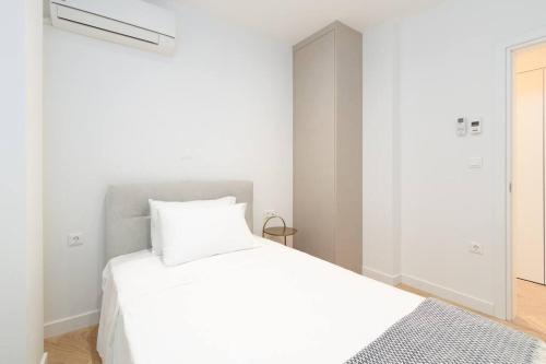 een witte slaapkamer met een wit bed en een spiegel bij Stunning Athens Riviera 3 BD Apt in Athene