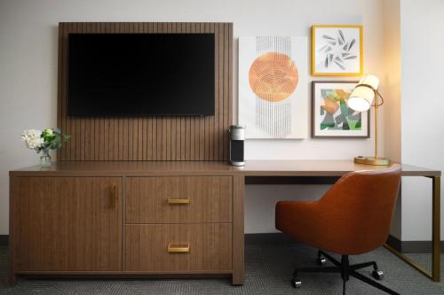 an office with a desk with a television on a wall at Holiday Inn Chicago O'Hare - Rosemont by IHG in Rosemont
