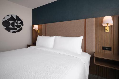 a bedroom with a large white bed with two lamps at Holiday Inn Chicago O'Hare - Rosemont by IHG in Rosemont