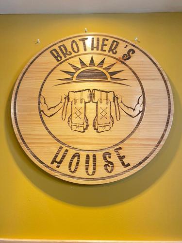 a wooden sign that reads hotter than a house at BROTHERs HOUSE in Cusco