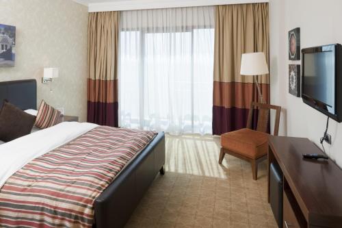 a hotel room with a bed and a flat screen tv at Staybridge Suites & Apartments - Citystars by IHG in Cairo