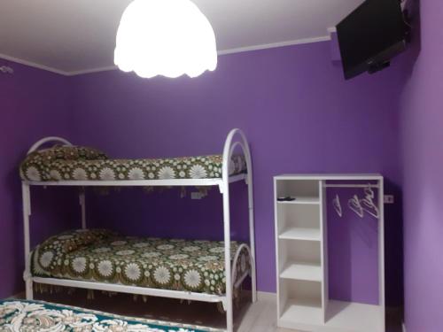 a purple room with a bunk bed and a tv at La Casa di Romeo in Ateleta