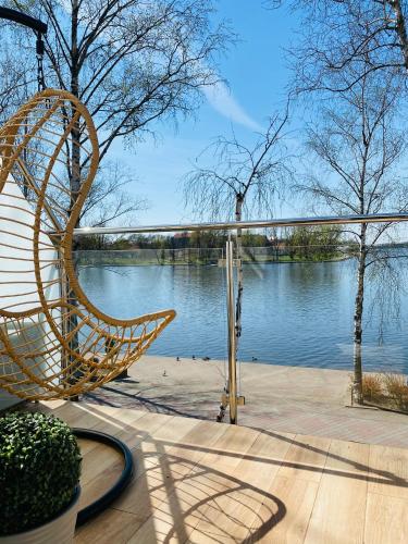 a chair sitting on a patio next to a body of water at Apartament MoLoo I in Ostróda