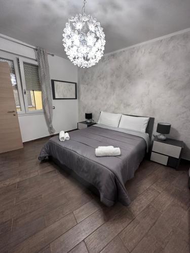 Un dormitorio con una cama grande y una lámpara de araña. en Rena Bianca Apartment, en Porto Torres