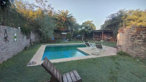 a swimming pool with two chairs in a yard at Casa Funes in Funes