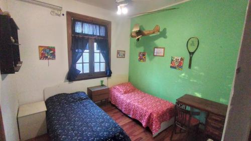 a green room with a bed and a window at Casa Funes in Funes