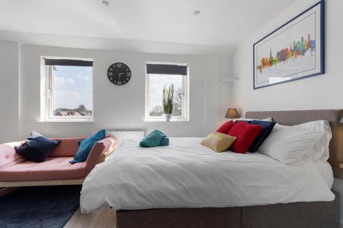 1 dormitorio con 1 cama grande y 1 sofá rosa en Exeter City Centre Apartments Baxter Apartment en Exeter