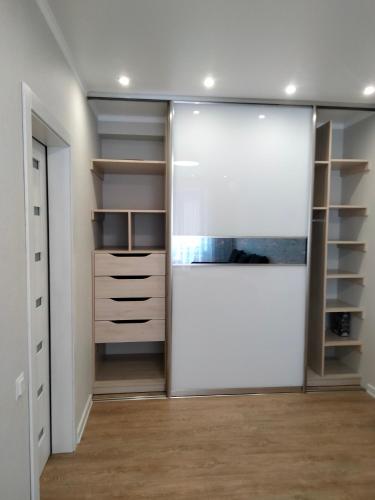 a walk in closet with a sliding glass door at ЖК Версаль парк in Irpin'