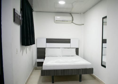 une petite pièce avec un lit et une fenêtre dans l'établissement Hotel Sol Del LLano, à Villavicencio