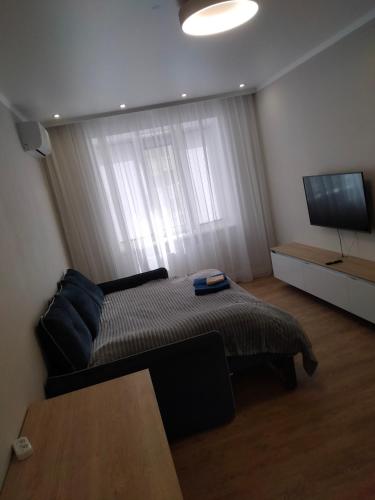 a bedroom with a bed and a flat screen tv at ЖК Версаль парк in Irpin'