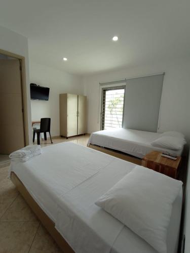 a bedroom with two beds and a desk and a chair at Hotel Palermo Sincelejo in Sincelejo