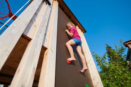 a young girl is climbing up a climbing wall at Bei FINK's in Sulzberg