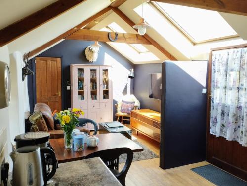 a living room with a ceiling with skylights at Cosy barn on rural smallholding with alpacas, goats & pigs in Stithians