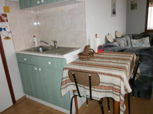 a kitchen with a table and a sink and a couch at György Vendégház in Magyarpolány