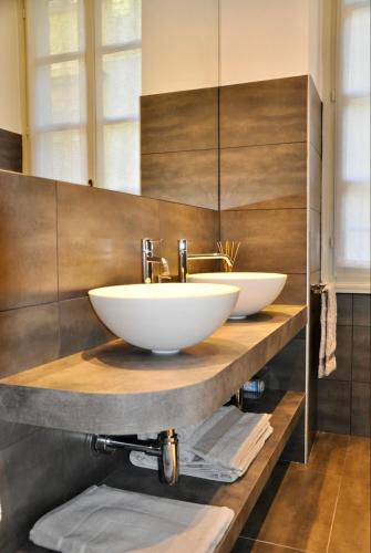 zwei Waschbecken auf einer Holzablage in einem Badezimmer in der Unterkunft CHARMING COMO - Apartment downtown in the pedestrian area with 2 double bedrooms and 2 complete bathrooms a spacious living room and full equipped kitchen in Como