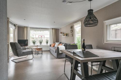 a living room with a couch and a table at Ruime luxe 4 persoons Chalet midden op de Veluwe in Hoenderloo