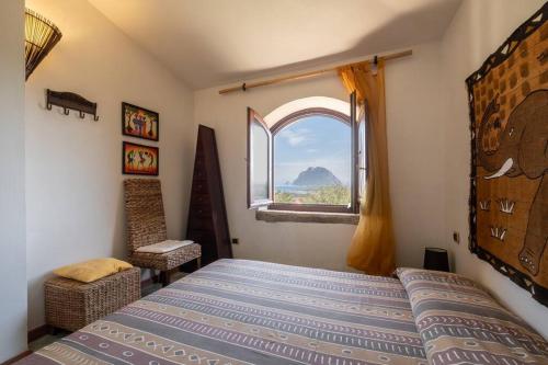 a bedroom with a bed and a window at [FREE Parking] Villa - stunning view of Tavolara in Porto San Paolo