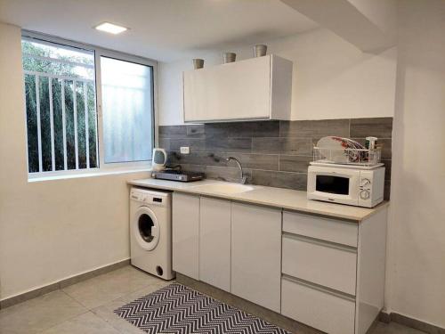 uma cozinha com um lavatório e uma máquina de lavar louça em Cute and cosy 2 rooms Apartment em Ashdod
