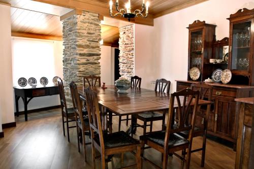 a dining room with a wooden table and chairs at Casa do Médico in Carção