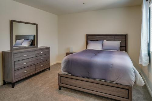 a bedroom with a bed and a dresser and a mirror at Inviting Henderson Townhome with Community Pool! in Las Vegas
