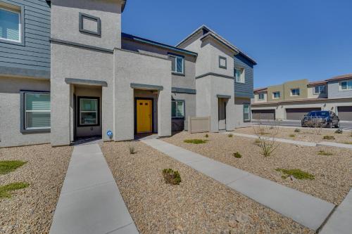 a house with a yellow door in a yard at Inviting Henderson Townhome with Community Pool! in Las Vegas