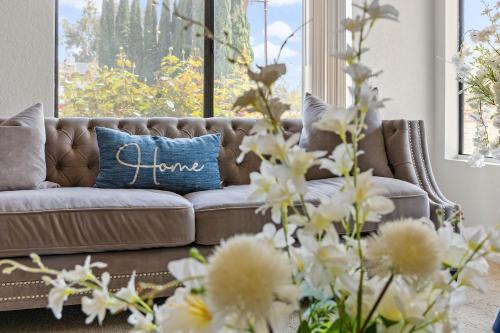 a couch with a blue pillow with the word home written on it at Peaceful Private Retreat In The Heart Of Town in Redlands