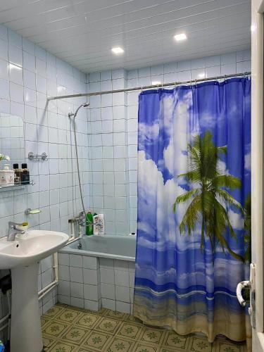 a bathroom with a shower curtain with a palm tree at Melson in Batumi
