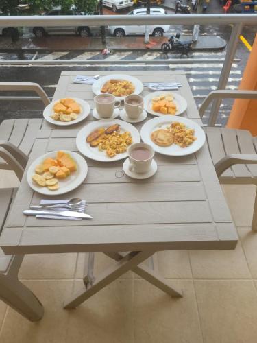 a picnic table with plates of food on it at Hotel el Turista in Florencia