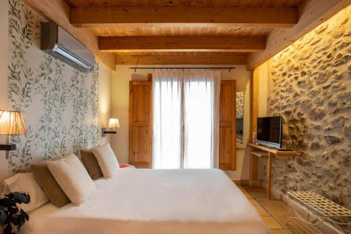 a bedroom with a large bed and a window at Hotel Boutique Niu de Sol - Designed for Adults in Palau-Saverdera