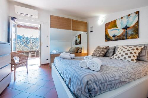 a bedroom with a large bed with towels on it at Tipica casa antica ligure – Ca' del Ciliegio in Calice Ligure