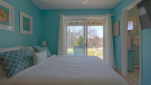 a blue bedroom with a large bed and a window at The Ocean Dunes at Amagansett in Amagansett