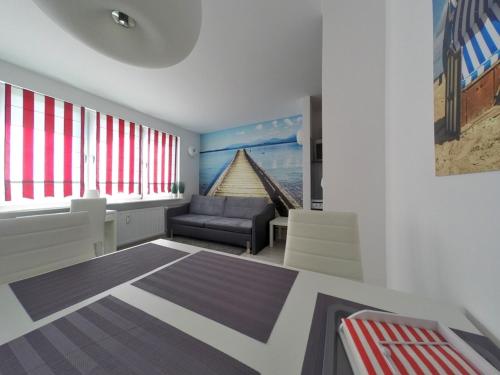 sala de estar con sofá y silla en Apartament z widokiem na morze, en Gdynia