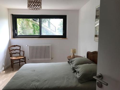 sypialnia z łóżkiem, krzesłem i oknem w obiekcie Maison Bertrand w mieście Saint-Marcellin