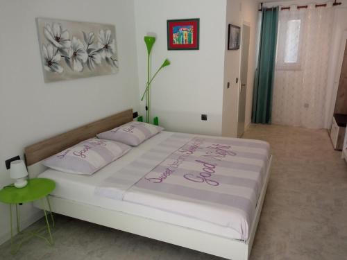 1 dormitorio con 1 cama con colcha blanca en Apartments & Rooms No.1, en Zadar