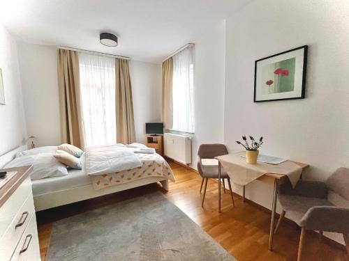 - une chambre avec un lit, une table et des chaises dans l'établissement Pension Tokus, à Nuremberg