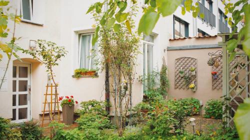 einen Garten vor einem Gebäude mit Pflanzen in der Unterkunft Pension Tokus in Nürnberg
