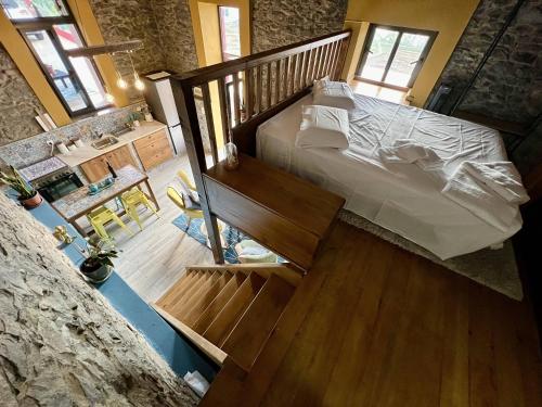 a bedroom with a large bed and a staircase at Victoria Tiny Stone House in Ponta do Pargo