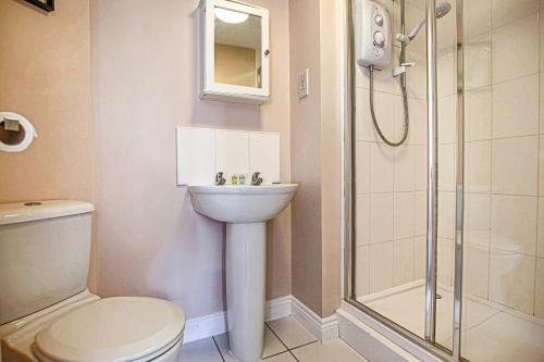 a bathroom with a shower and a toilet and a sink at Stylish Two Bedroom, Two Bathroom Apartment with Free Parking, WiFi & Sky TV in Milton Keynes by HP Accommodation in Milton Keynes