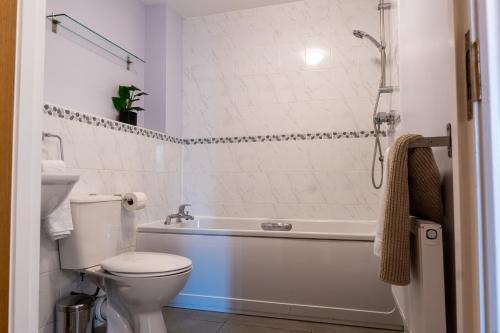 ein Bad mit einer Badewanne, einem WC und einer Dusche in der Unterkunft Homely Two Bedroom Apartment in Milton Keynes - Free Parking, WiFi, Sky TV & Netflix in Milton Keynes