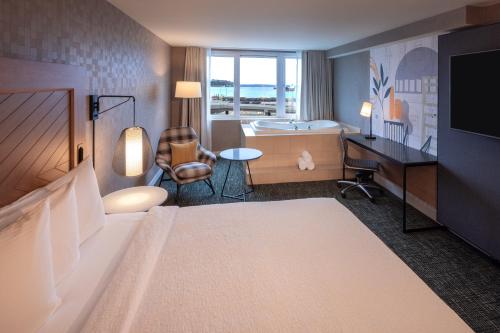 シアトルにあるシルバー クラウド ホテル シアトル スタジアムのベッド、デスク、テレビが備わるホテルルームです。