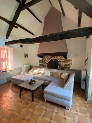 un salon avec un canapé et une cheminée dans l'établissement Les Bruyères Rebecca, à Pleugueneuc