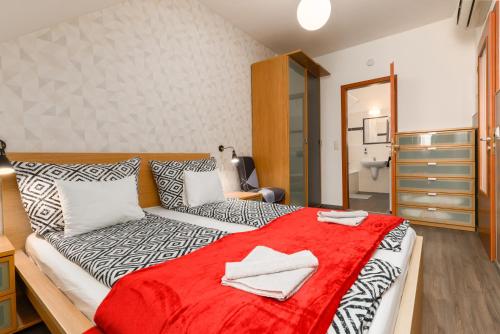 a bedroom with a bed with a red blanket on it at Lovag charming apartment in the center-AC in Budapest