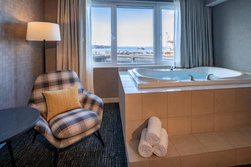 ein Badezimmer mit einer Badewanne, einem Stuhl und einem Tisch in der Unterkunft Silver Cloud Hotel - Seattle Stadium in Seattle