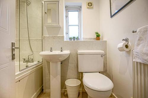 uma casa de banho branca com um WC e um lavatório em Spacious 3 Bedroom Home in Milton Keynes by HP Accommodation - Free Parking, WiFi & Sky TV em Milton Keynes