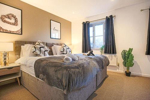 Un dormitorio con una cama grande y una ventana en Spacious 3 Bedroom Home in Milton Keynes by HP Accommodation - Free Parking, WiFi & Sky TV en Milton Keynes