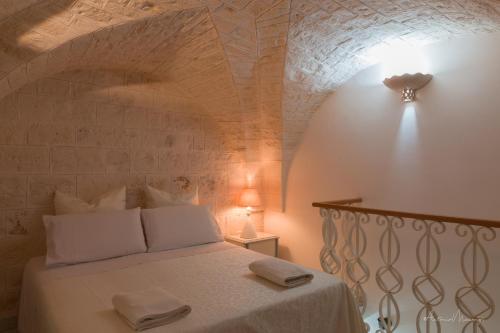 a bedroom with a bed with two towels on it at Bomboniera di Cisternino in Cisternino