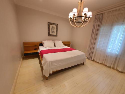 une chambre avec un lit et un lustre dans l'établissement JV guesthouse, à Durban