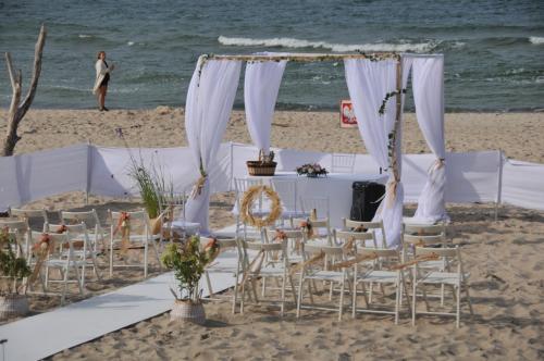 a wedding on the beach with chairs and a table at Ośrodek Wypoczynkowy Wielki Błękit in Łukęcin