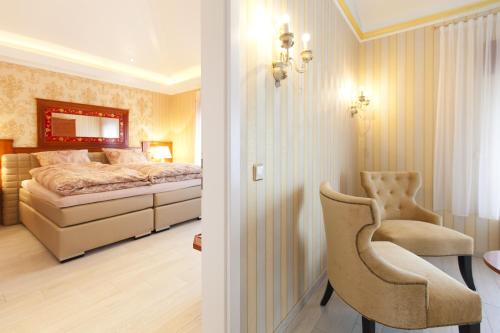 ヒュルトにあるHotel-Restaurant Breitenbacher Hofのベッドと椅子のある寝室
